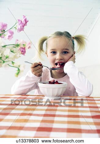 Girl eating strawberries with milk View Large Photo Image Stock Image - Girl eating strawberries with milk. Fotosearch