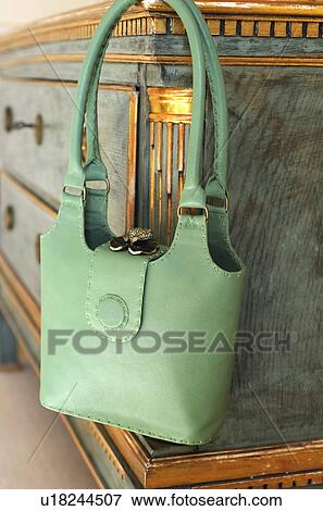 Green handbag hanging at sideboard View Large Photo Image Stock Photo - Green handbag hanging at sideboard. Fotosearch