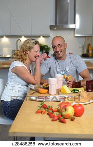 Happy couple having breakfast in kitchen View Large Photo Image Stock Photo - Happy couple having breakfast in kitchen. Fotosearch