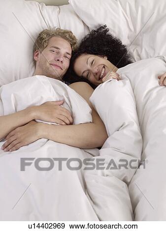 Stock Photo - Happy couple in bed. Fotosearch