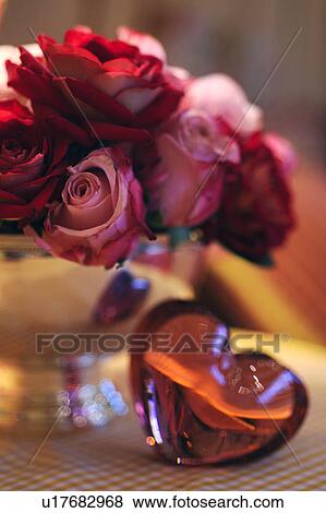 Stock Photo - Heart-shaped worry stone and bunch of roses. Fotosearch