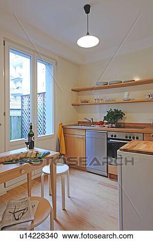 Stock Image - Kitchen with bottle of wine on table. Fotosearch