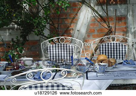Stock Photograph - Laid breakfast table on terrace. Fotosearch