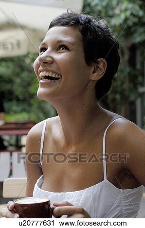 Laughing young woman with cup of coffee outdoors View Large Photo Image Stock Image - Laughing young woman with cup of coffee outdoors. Fotosearch