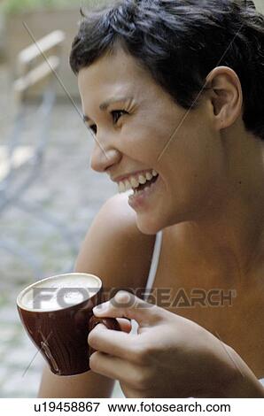 Laughing young woman with cup of coffee outdoors View Large Photo Image Stock Photo - Laughing young woman with cup of coffee outdoors. Fotosearch