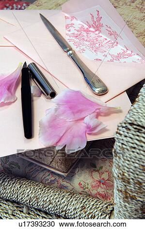 Stock Image - Letter, rose petals, stylograph and letter opener on chair. Fotosearch