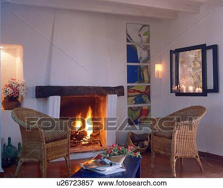 Living room with wicker chairs by the fireplace View Large Photo Image Stock Photo - Living room with wicker chairs by the fireplace. Fotosearch