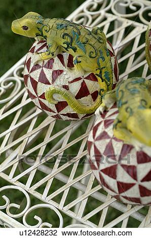Stock Image - Lizard figurines on gazing balls. Fotosearch