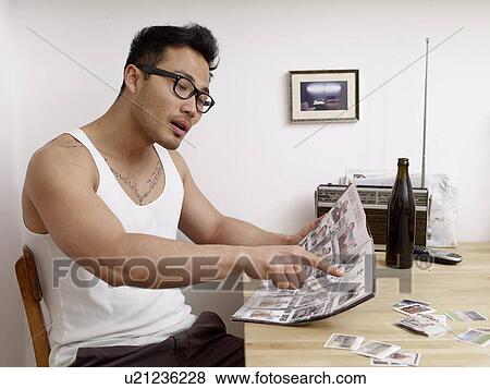 Stock Photo - Man holding soccer collectors album. Fotosearch