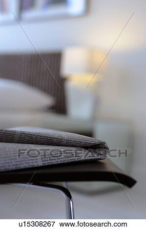 Stock Photo - Newspaper on chair in modern bedroom. Fotosearch