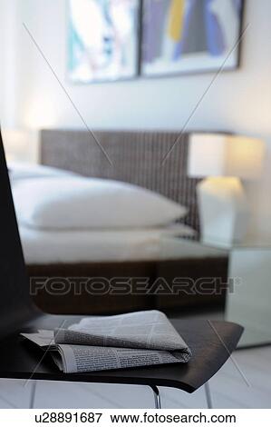 Newspaper on chair in modern bedroom View Large Photo Image Stock Photo - Newspaper on chair in modern bedroom. Fotosearch