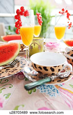 Stock Photo - Orange juice with redcurrants and water melon on table. Fotosearch