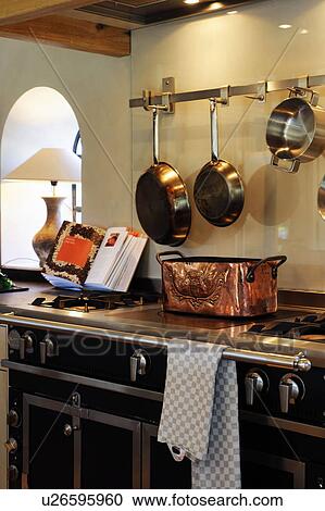 Stock Image - Pans and cookbook at stove in kitchen. Fotosearch