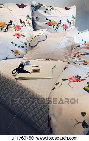 Stock Image - Pillows and duvet with bird and flower imprint. Fotosearch