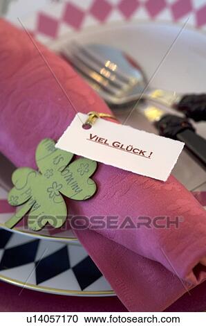 Stock Image - Place setting with four leaf clover and note. Fotosearch