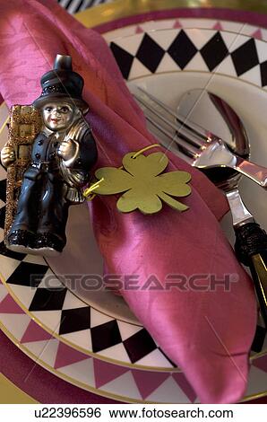 Stock Photograph - Plate with figurine and four leaf clover. Fotosearch