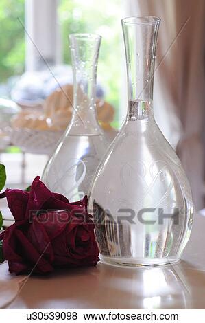 Red rose next to glass vases View Large Photo Image Stock Photo - Red rose next to glass vases. Fotosearch