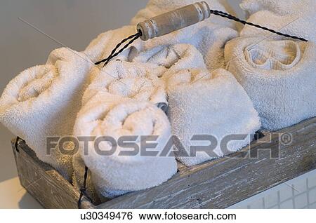 Stock Photograph - Rolls of bath towels in a tray. Fotosearch