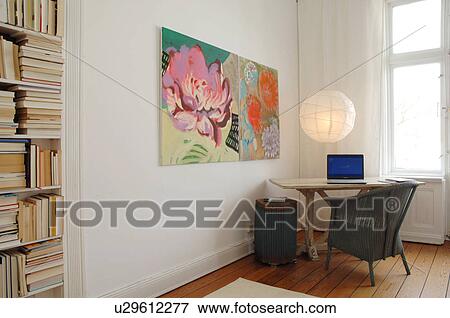 Stock Photo - Room with bookshelf, paintings and laptop on table. Fotosearch