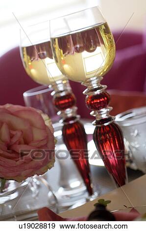 Stock Photo - Rose blossom and two glasses of wine. Fotosearch