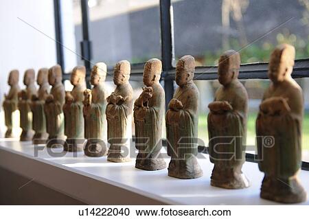 Stock Image - Row of statuettes at the window. Fotosearch