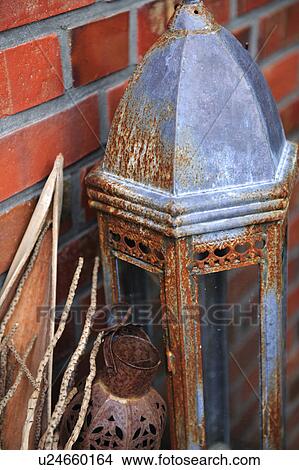 Picture - Rusty lantern in front of brick wall. Fotosearch
