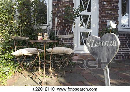 Sign and table with chairs at house entrance View Large Photo Image Stock Image - Sign and table with chairs at house entrance. Fotosearch