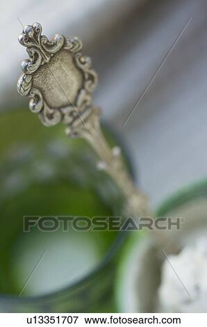 Stock Photo - Silver spoon in green glass. Fotosearch
