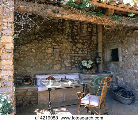 Stock Photo - Sitting area at a stone house. Fotosearch