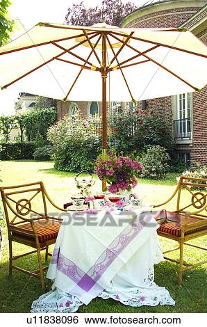 Stock Photograph - Sitting area in garden with sunshade. Fotosearch