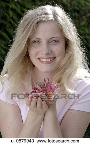 Smiling woman holding honeysuckle View Large Photo Image Stock Image - Smiling woman holding honeysuckle. Fotosearch