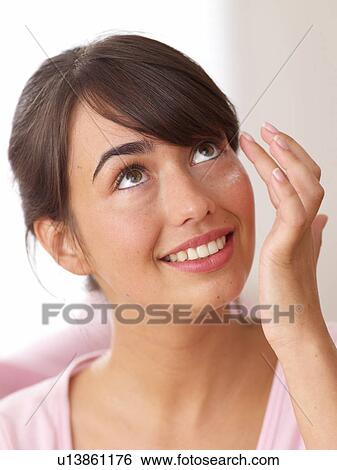 Stock Photograph - Smiling young woman looking up. Fotosearch