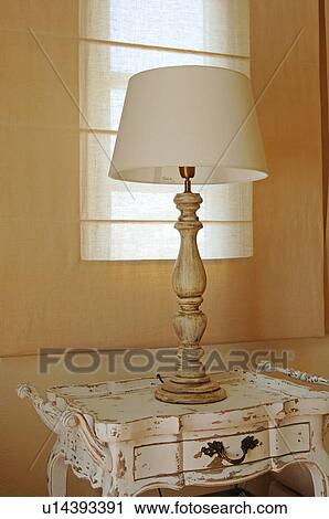 Stock Image - Table lamp on antique dresser. Fotosearch