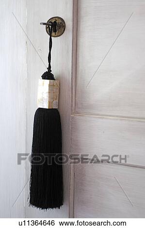 Stock Photograph - Tassel hanging at closed door. Fotosearch