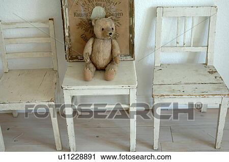 Stock Image - Teddy bear on wooden chair. Fotosearch