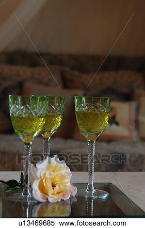 Stock Photography - Three drinking glasses and flower blossom on table. Fotosearch