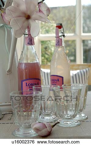 Stock Photograph - Two bottles of lemonade and drinking glasses. Fotosearch