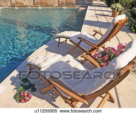 Stock Photography - Two deckchairs by the poolside. Fotosearch