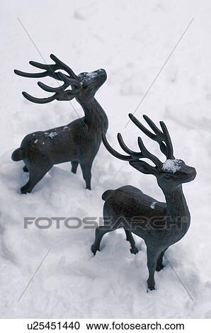 Stock Image - Two deer figurines in snow. Fotosearch