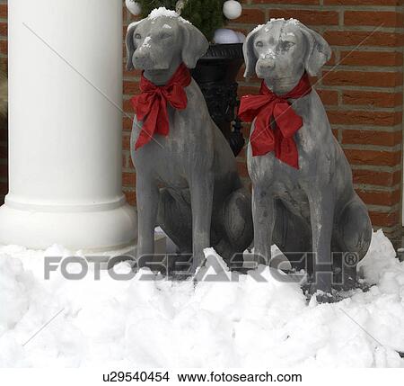 Picture - Two dog statuettes in snow. Fotosearch