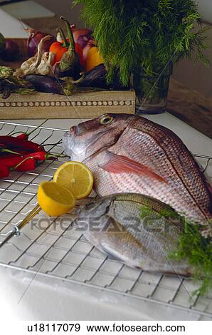 Two fishes with lemons and vegetable View Large Photo Image Stock Photo - Two fishes with lemons and vegetable. Fotosearch
