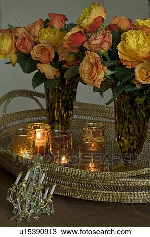 Stock Image - Two flower vases and candles on golden tray. Fotosearch