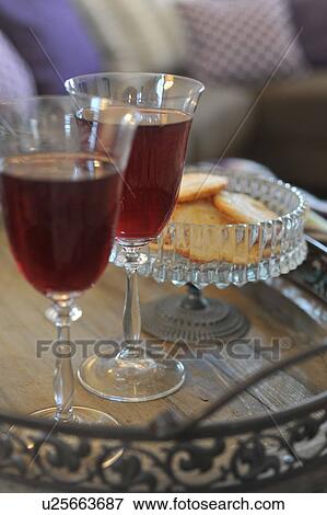 Stock Photo - Two glasses of red wine and bowl with cookies. Fotosearch