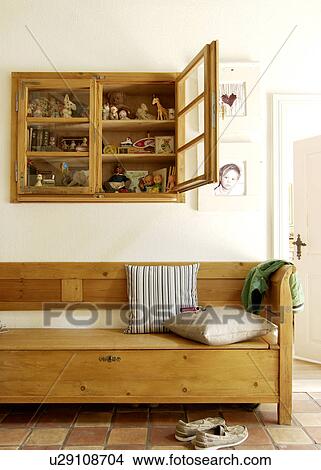 Picture - Vitrine with figurines above wooden bench. Fotosearch