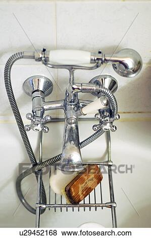 Stock Photo - Water tap and nailbrush at bathtub. Fotosearch