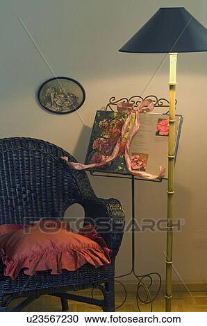 Wicker chair, floor lamp and book with flowers View Large Photo Image Stock Image - Wicker chair, floor lamp and book with flowers. Fotosearch
