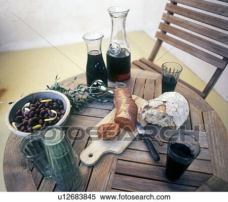 Stock Photography - Wine, bread, sausage and bean salad on wooden table. Fotosearch