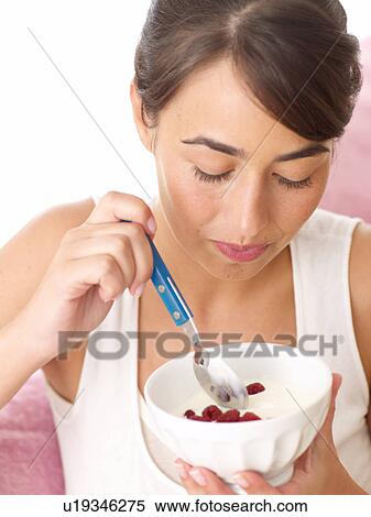 Woman eating yogurt with raspberries View Large Photo Image Stock Photography - Woman eating yogurt with raspberries. Fotosearch