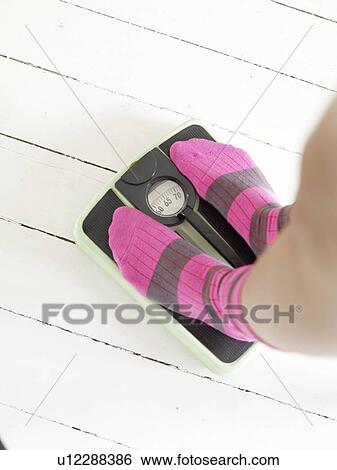 Woman in woolen socks standing on scales View Large Photo Image Stock Photograph - Woman in woolen socks standing on scales. Fotosearch
