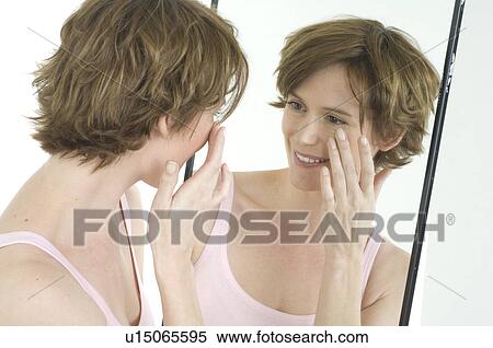 Stock Photography - Woman looking in mirror. Fotosearch